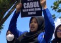Para mahasiswa sedang membentangkan poster dan spanduk kecaman, di depan Gedung DPRD Pandeglang, Selasa (29/11/2022). (NIPAL SUTIANA/SATELITNEWS.COM).