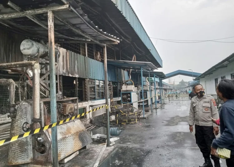 Sejumlah personel dari Polsek Cikande Polres Serang, memeriksa bagian gedung yang terbakar pada PT. PWI 1 Serang, Selasa (8/11). (ISTIMEWA)