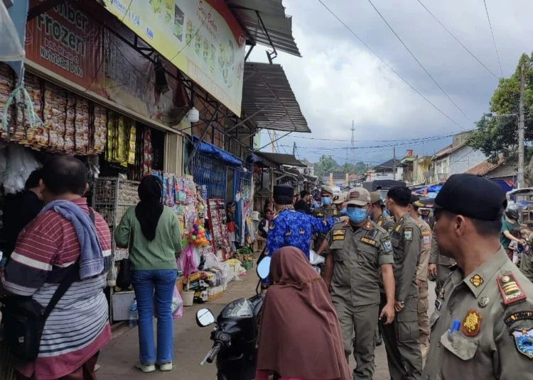 Anggota Satpol PP Pandeglang, menertibkan dan menindak para PKL di sepanjang Jalan Yumaga, Pasar Badak, Kabupaten Pandeglang, Senin (19/12/2022). (ISTIMEWA)