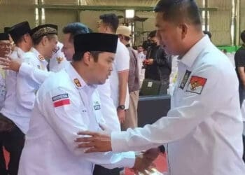 Fahmi Hakim (kanan), sedang berjabatan tangan dengan seorang Kepala Desa, di Kabupaten Serang. (SIDIK/SATELITNEWS.COM)
