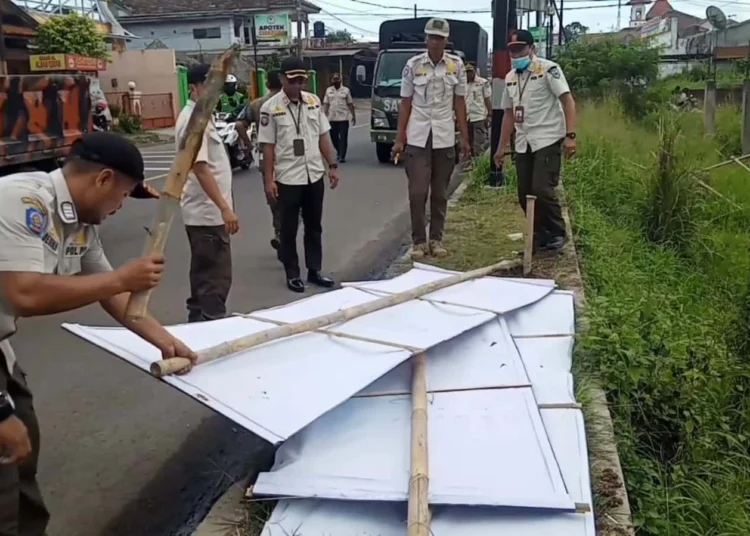 Sejumlah anggota Satpol PP Kabupaten Pandeglang, menertibkan baliho dan spanduk serta sejenisnya, di beberapa titik, Rabu (14/12/2022). (ISTIMEWA)