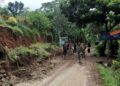 Warga membenahi tanah tebing yang longsor, di sepanjang ruas jalan Tegalwangi – Kubangkondang, Desa Tegalwangi, Kecamatan Menes, Kabupaten Pandeglang, Rabu (25/1/2023). (ISTIMEWA)