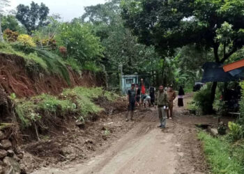 Warga membenahi tanah tebing yang longsor, di sepanjang ruas jalan Tegalwangi – Kubangkondang, Desa Tegalwangi, Kecamatan Menes, Kabupaten Pandeglang, Rabu (25/1/2023). (ISTIMEWA)