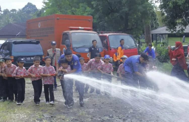 Petugas BPBDPK Pandeglang, sedang mengajarkan penggunaan alat Pemadam Kebakaran (Damkar) sejak dini, kepada pelajar di salah satu Sekolah Dasar (SD) di Pandeglang, Rabu (18/1/2023). (ISTIMEWA)