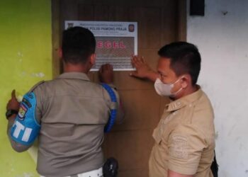 DISEGEL: Petugas Satpol PP Kabupaten Tangerang sedang menyegel dua kamar kontrakan yang menjadi lokasi prostitusi. (ISTIMEWA)