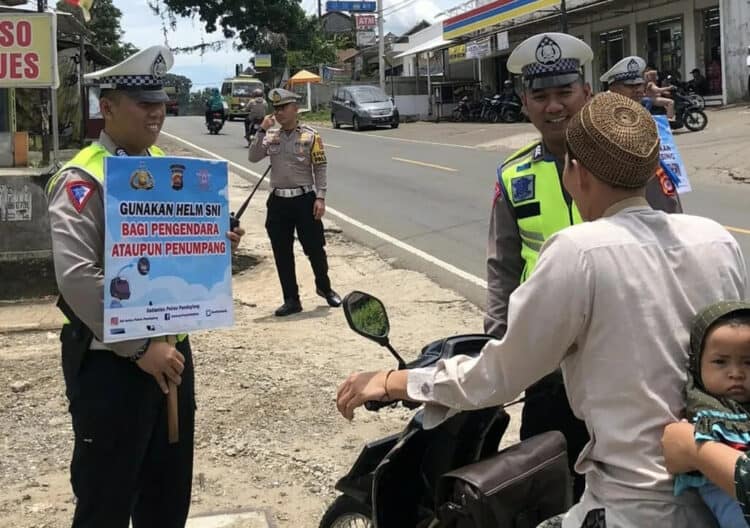 IMBAUAN–Jajaran personel Satlantas Polres Pandeglang, sedang memberika imbauan kepada para pengendara yang melintas di jalan Serang – Pandeglang, Selasa (7/2/2023). (NIPAL SUTIANA/SATELITNEWS.COM)