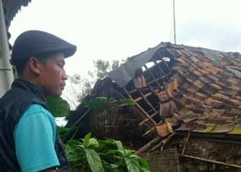 MONITOR–Seorang relawan kebencanaan, sedang monitor lokasi musibah rumah rusak akibat diterjang angin kencang, di beberapa kecamatan di Kabupaten Pandeglang, Selasa (28/2/2023). (ISTIMEWA)