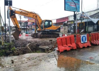 PERBAIKAN GORONG – GORONG–Ekskavator atau mesin pengeruk, diparkir di Jalan Raya Labuan – Pandeglang, tepatnya di perempatan Pasar Maja, Kecamatan Majasari, Kabupaten Pandeglang. Karena sedang ada proyek perbaikan saluran air di lokasi tersebut, Minggu (12/2/2023). (MARDIANA/SATELITNEWS.COM)