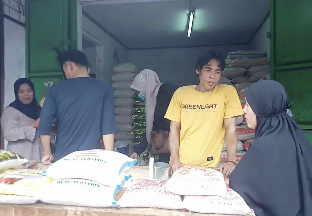 Seorang penjual beras di Pasar Badak Pandeglang, sedang melayani pembeli, Kamis (2/3/2023). (NIPAL SUTIANA/SATELITNEWS.COM)