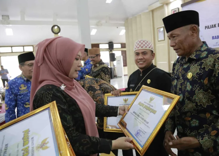 PENGHARGAAN–Bupati Pandeglang Irna Narulita, memberikan penghargaan kepada wilayah yang PBB-nya lunas, melalui Kades, di Pendopo Bupati Pandeglang, beberapa waktu lalu. (ISTIMEWA)