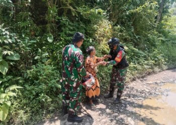 Anggota Koramil 0115 Cimanggu Kodim 061 Pandeglang, membantu warga yang kelelahan, Senin (13/3/2023). (ISTIMEWA)