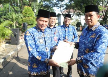 Wali Kota Serang Syafruddin (kanan), serahkan SK promosi kepada seorang pejabat dilingkungan Pemkot Serang, Jumat (17/3/2023). (LUTHFI/SATELITNEWS.COM)