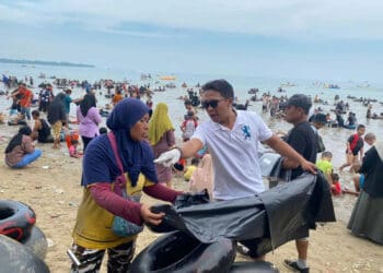 Koordinator KPPC, Franky Supriadi, membagikan plastik sampah kepada pedagang, untuk membantu membuang dan mengumpulkan sampah pada tempatnya, Minggu (30/4/2023). (ISTIMEWA)