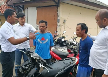 Kedua pelaku Curanmor, didampingi personel Satreskrim Polres Pandeglang, sedang menunjukkan motor yang dicurinya, Rabu (17/7/2023) lalu. (ISTIMEWA)