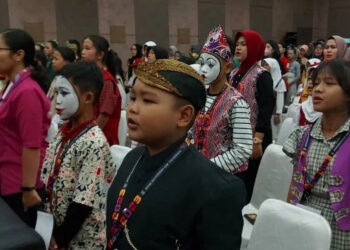 BERPAKAIAN ADAT: Terlihat ratusan anak dengan mengenakan pakaian adat sedang berdiri bernyanyi lagu kebangsaan Indonesia sebelum dilakukannya acara FLS2N di Hotel Lemo, Kecamatan Kelapa Dua, Selasa (22/5). (ALFIAN HERIANTO)