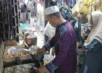 HARGA TELUR AYAM MELAMBUNG TINGGI–Pedagang telur ayam, di pasar tradisional Pandeglang, sedang melayani pembeli, Rabu (24/5/2023). (NIPAL SUTIANA/SATELITNEWS.COM)