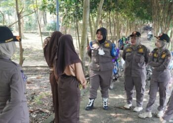 EDUKASI: Prajawati Kabupaten Tangerang dan Tim Reaksi Cepat (TRC) saat memberikan edukasi kepada dua siswi yang asyik nongkrong saat jam sekolah di tapi danau Puspemkab Tangerang, Tigaraksa, Kamis (22/6/2023). (ISTIMEWA)