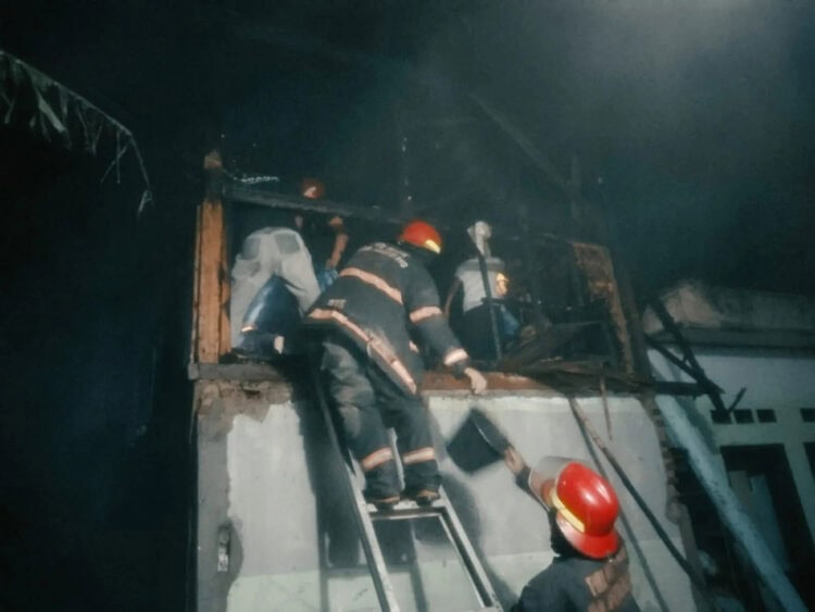 Tim Damkar BPBDPK Kabupaten Pandeglang dan beberapa petugas lainnya, sedang menanggulangi dampak kebakaran di Kelurahan Karaton, Kecamatan Majasari, Kabupaten Pandeglang, Kamis (6/7/2023) malam. (ISTIMEWA)