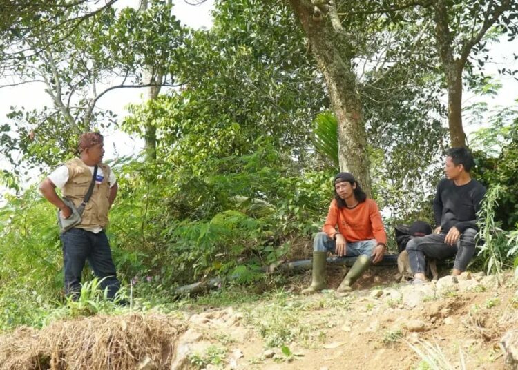 Lurah Juhut, M. Syahrul, berbincang dengan petani, Kamis (31/8/2023). (FAHRIE/SATELITNEWS.COM)