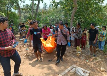 MEMBAWA MAYAT–Personel Posek Labuan Polres Pandeglang, dibantu warga sekitar membawa mayat diduga korban tenggelam di Sungai Cisanggoma, Minggu (1/10/2023). (ISTIMEWA)