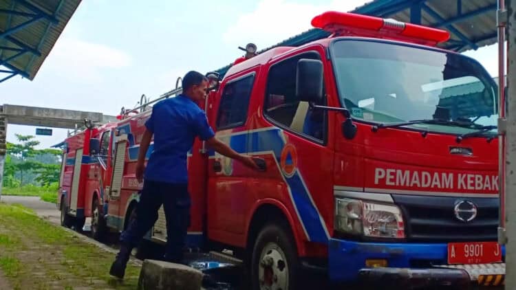 Petugas BPBDPK Kabupaten Pandeglang, memeriksa mobil Damkar yang sedang terparkir, di halaman kantor instansi setempat, Selasa (21/11/2023). (FAHRIE/SATELITNEWS.COM)