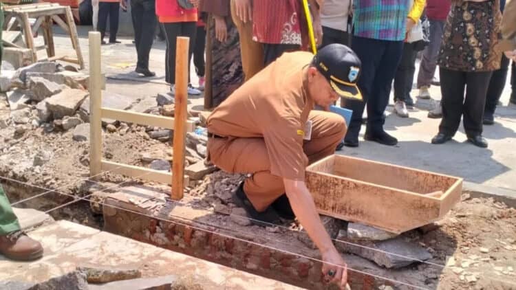Kepala DPKPP Kabupaten Pandeglang, Roni, melakukan peletakan batu pertama pembangunan Rumah Tidak Layak Huni (RTLH), Senin (4/12/2023). (FAHRIE/SATELITNEWS.COM)