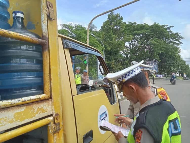 Personel Satlantas Polres Pandeglang, memeriksa kelengkapan surat - surat kendaraan yang melintas di Pasar Badak Pandeglang, Senin (4/3/2024). (ADIB FAHRIE/SATELITNEWS.COM)