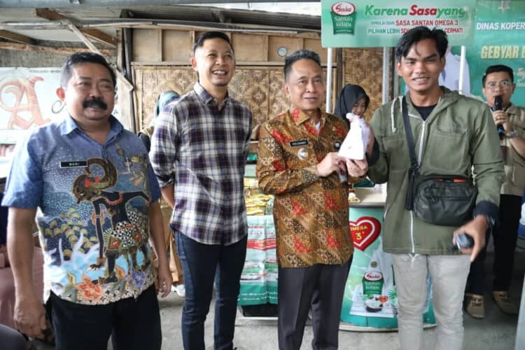 Pj Walikota Serang Yedi Rahmat, menyerahkan secara simbolis paket sembako subsidi kepada seorang warga di Cipocok Jaya, Kota Serang. (LUTHFI/SATELITNEWS.COM)