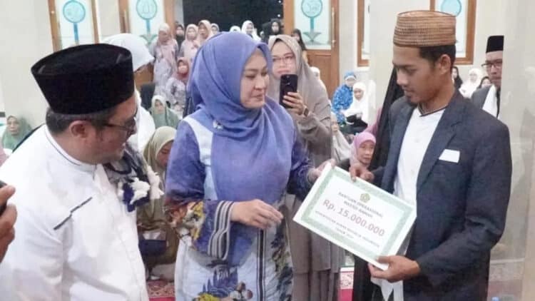 MENYERAHKAN BANTUAN : Bupati Irna Narulita (tengah) menyerahkan bantuan secara simbolis di Masjid Jami Baitul Muttaqin Kampung Ciporokoy, Desa Sinarjaya, Kecamatan Mandalawangi. (ADIB)