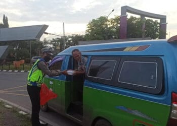 MEMBERIKAN TAKJIL: Seorang anggota Polresta Tangerang Polda Banten saat membagikan takjil kepada pengendara atau pejalan kaki. (ISTIMEWA)