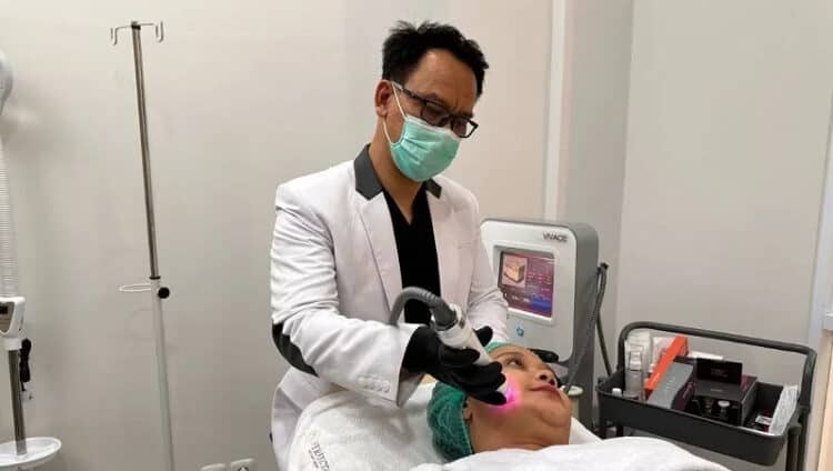 Andy Prasetia, dokter dan Founder Perfecta Aesthetic Clinic sedang melakukan treatment kepada konsumen.