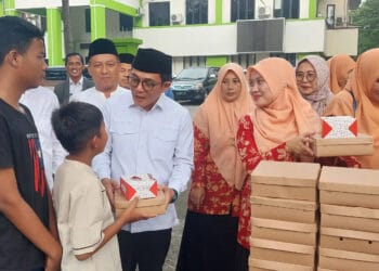 PEMBAGIAN TAKJIL: Kepala Kantor Kemenag Kabupaten Tangerang H. A. Baijuri bersama Ketua DWP Kemenag Kabupaten Tangerang Ifon Italiana Baijuri, didampingi jajaran pegawai Kemenag saat membagikan takjil gratis kepada warga yang mengantre, Selasa (2/4/2024). (FAJAR ADITYA K)