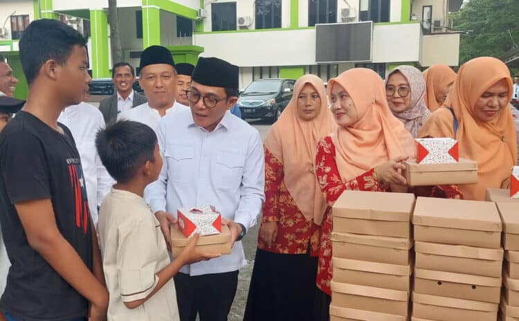 PEMBAGIAN TAKJIL: Kepala Kantor Kemenag Kabupaten Tangerang H. A. Baijuri bersama Ketua DWP Kemenag Kabupaten Tangerang Ifon Italiana Baijuri, didampingi jajaran pegawai Kemenag saat membagikan takjil gratis kepada warga yang mengantre, Selasa (2/4/2024). (FAJAR ADITYA K)