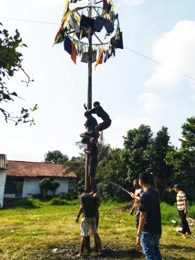 Para peserta panjat pinang, sedang berusaha bahu membahu untuk meraih ujung (hadiah).(MARDIANA/SATELITNEWS.COM)
