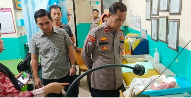 Personel kepolisian setempat, melihat bayi yang ditemukan dalam kardus, di wilayah Kecamatan Cikande, Kabupaten Serang, Kamis (15/1/2025). (ISTIMEWA)