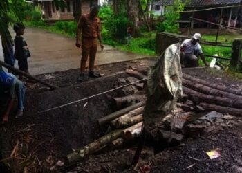 Camat Sindangresmi Muklis Arifin (tengah) meninjau jembatan Cikupaeun yang amblas. (ISTIMEWA)