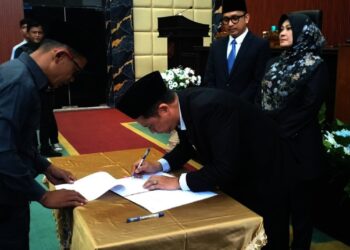 Ketua DPRD Pandeglang Tb Agus Khatibul Umam menandatangani berita acara rapat paripurna usulan pemberhentian Bupati dan Wakil Bupati Pandeglang. (ADIB FAHRIE/SATELITNEWS.COM)
