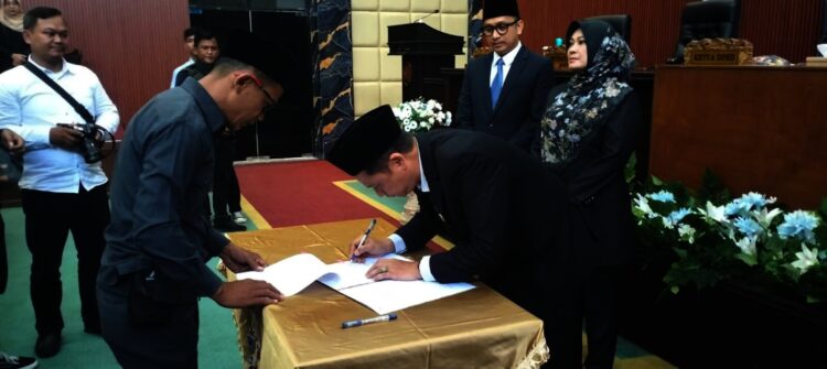 Ketua DPRD Pandeglang Tb Agus Khatibul Umam menandatangani berita acara rapat paripurna usulan pemberhentian Bupati dan Wakil Bupati Pandeglang. (ADIB FAHRIE/SATELITNEWS.COM)
