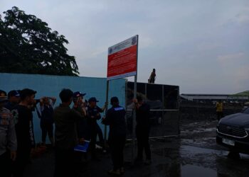 Petugas KLH memasang papan peringatan penyegelan di TPA Jatiwaringin. (ALFIAN/SATELITNEWS)