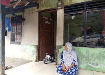 Seorang lansia di Kampung Karet, Desa Teluk, Kecamatan Labuan duduk diteras rumahnya. (ISTIMEWA)