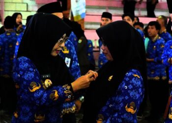Bupati Pandeglang Raden Dewi Setiani (kiri), sematkan penghargaan kepada ASN berprestasi di acara Puncak HUT Korpri Ke-54, di gedung Grha Pancasila Kabupaten Pandeglang, Senin (1/12). (ISTIMEWA)