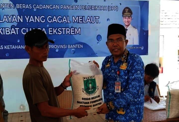 MENYERAHKAN BANTUAN : Kepala Dinas Ketahanan Pangan Banten, Nasir M Daud (kanan) menyerahkan bantuan beras CPP kepada warga Pulau Tunda. (ISTIMEWA)