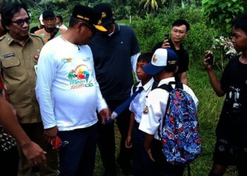 Gubernur Banten Andra Soni, berbincang dengan anak sekolah saat meninjau ruas jalan di Desa Sukarame, Kecamatan Carita, Kabupaten Pandeglang. (ADIB FAHRIE/SATELIT NEWS).j