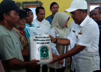 MEMBERIKAN BANTUAN BERAS : Kepala DKP Banten Nasir M Daud (kanan), memberikan bantuan beras kepada nelayan Teluk, Kecamatan Labuan, Kabupaten Pandeglang. (ISTIMEWA)