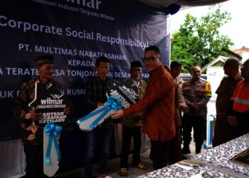 Head Kawasan Indistri Terpadu Wilmar Byron Oswald Salim, secara simbolis menyerahkan replika kunci kepada penerima bantuan di Desa Pulo Panjang, Kecamatan Puloampel, belum lama ini. (ISTIMEWA)