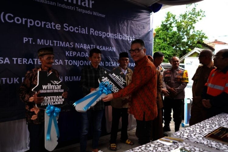 Head Kawasan Indistri Terpadu Wilmar Byron Oswald Salim, secara simbolis menyerahkan replika kunci kepada penerima bantuan di Desa Pulo Panjang, Kecamatan Puloampel, belum lama ini. (ISTIMEWA)