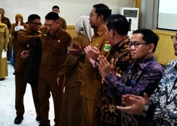 MEMAKAIKAN JAKET : Gubernur Banten Andra Soni, memakaikan jaket sebagai simbol dibentuknya tim Satgas percepatan penanganan aset situ. (ADIB FAHRIE/SATELITNEWS.COM)