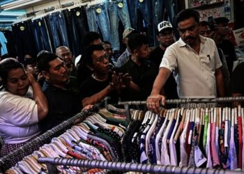 Menteri UMKM Maman Abdurrahman (kedua kanan) dan Wakil Ketua Badan Aspirasi Masyarakat DPR RI Adian Napitupulu (ketiga kiri) berbincang dengan pedagang, di area perdagangan pakaian bekas impor (thrifting) di Pasar Senen, Jakarta, Minggu (30/11/2025). (ISTIMEWA)