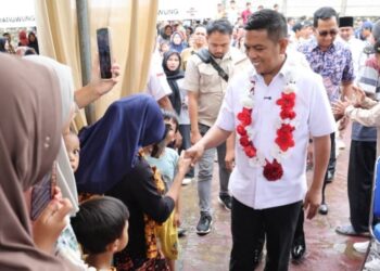 BERSALAMAN : Gubernur Banten Andra Soni, bersalaman dengan warga Pasir Jaya, Kecamatan Jatiuwung, Kota Tangerang, saat meresmikan jalan Kopi. (ISTIMEWA)