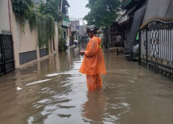 Petugas BPBD Kota Tangerang Selatan memantau kondisi banjir yang dipicu hujan lebat pada Senin (12/1). BMKG memprakirakan cuaca buruk masih akan terjadi. (ISTIMEWA)